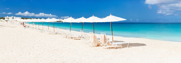 Fototapeta na wymiar Chairs and umbrellas on tropical beach