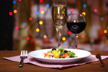 Tasty salad on dark background with bokeh  defocused lights