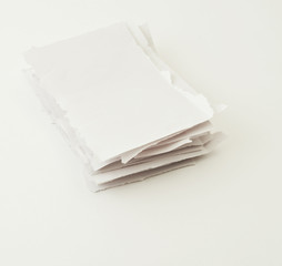 Stack of torn paper pieces over white