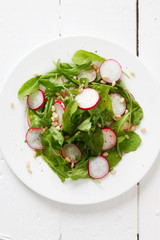 Salad with arugula, radish and pine nuts
