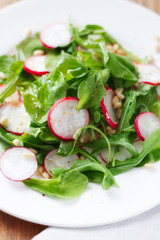 Salad with arugula, radish and pine nuts