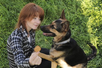 Young woman playing with a dog in the park