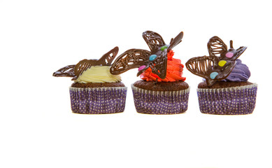 Chocolate butterfly decorated cupcakes on white background