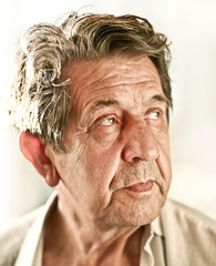 Elderly closeup sad man's face over white background