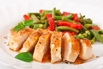 Chicken breast with vegetables and sauce decorated with basil