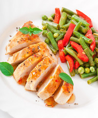 Chicken breast with vegetables and sauce decorated with basil