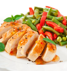 Chicken breast with vegetables and sauce decorated with basil