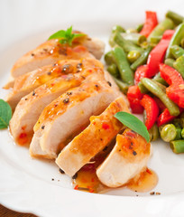 Chicken breast with vegetables and sauce decorated with basil