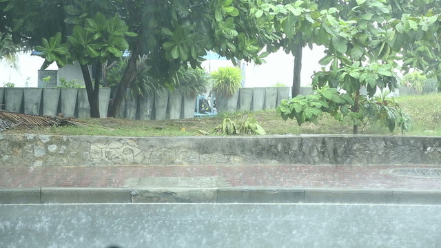 Heavy rain falling down on city street.