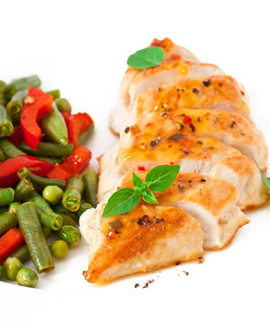 Chicken breast with vegetables and sauce decorated with basil