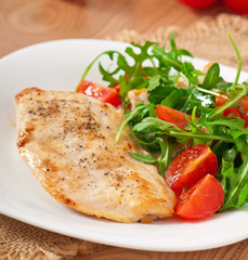 grilled fillet of chicken and a salad of arugula and tomato