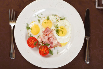fried eggs with bacon and vegetables
