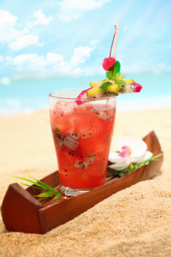 Cold tropical fruit cocktail on a beach