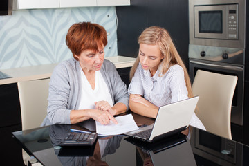 Two women discussing documents at home