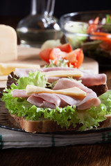 Sandwiches with cheese, ham and lettuce. Dark tone