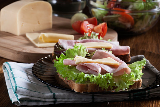Sandwiches with cheese, ham and lettuce. Dark tone