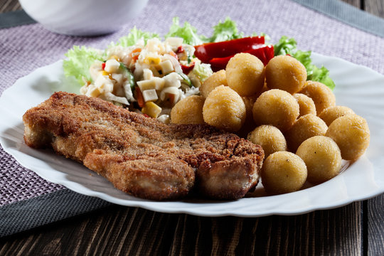 Breaded chop, prepared potatoes and salad. Mysterious light