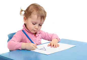 Little scholar writing in the school desk.