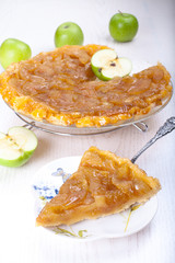 Apple tart tatin with a slice on a table