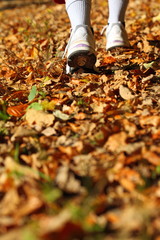 Woman walking cross country trail in autumn forest