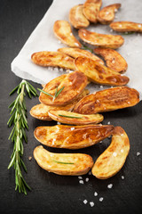 Fried potatoes with herbs and salt on a board slate