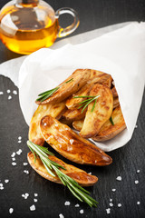 fried potatoes with rosemary and salt on a board slate