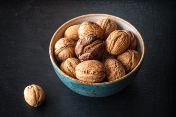 Walnuts in a bowl on a slate board
