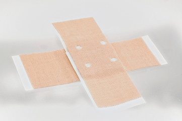 Heftpflaster über Kreuz