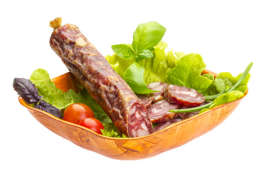 Ripe salami with salad, basil, onion and tomato