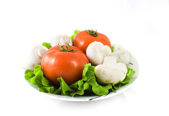 Tomatoes and mushrooms in a plate isolated on white