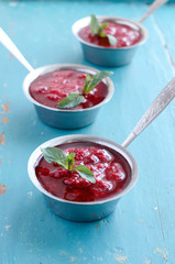 Raspberry sauсe with mint leaf on blue wooden background