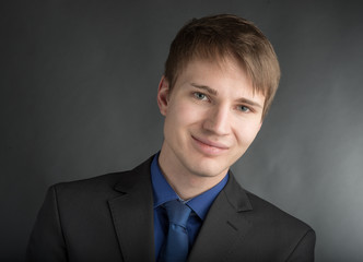 junger Lehrling schaut l&auml;chelnd in die Kamera