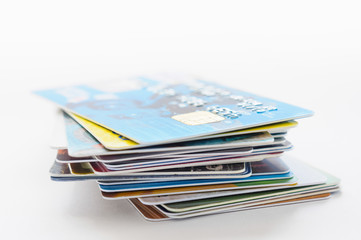 A pile of several colored credit cards on white background	