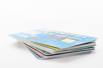 A pile of several colored credit cards on white background
