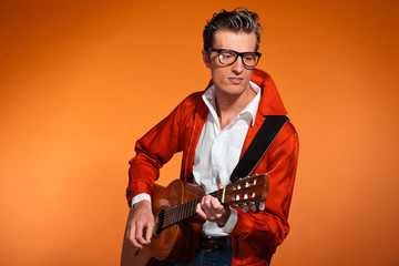 Retro fifties musician with glasses playing acoustic guitar.