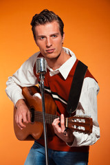 Retro fifties rock and roll singer playing acoustic guitar.