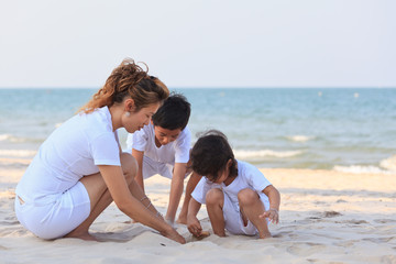 Asian family play sand on beach