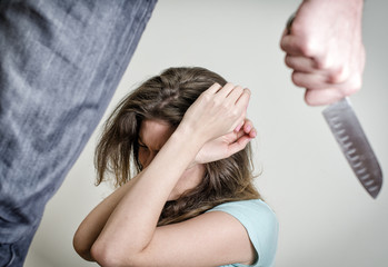 Naklejka premium Man with knife coming to his wife. Home violence concept
