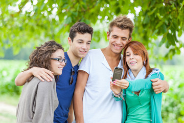 Group of Teenage Friends Taking Self Portraits with Mobile Phone