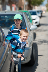 Naklejka premium schulkinder zwischen parkenden autos