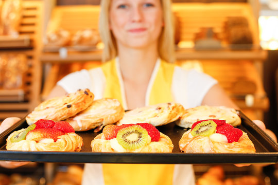 Bakery shopkeeper with tablet of cakes