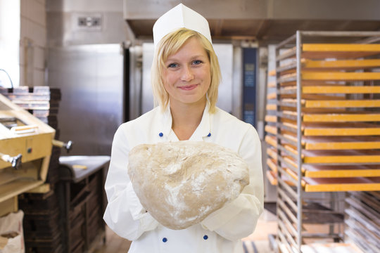 Baker with bread dough in bakery