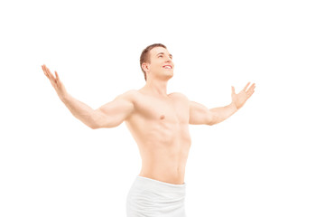Young athletic male in a towel spreading his arms