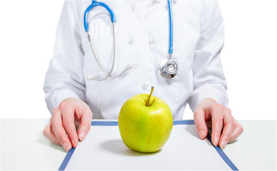 Doctor sits at table with an apple