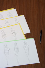 designer assessing fashion drawings