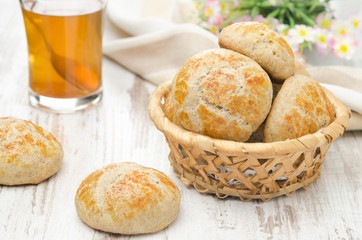 homemade cottage cheese bread rolls in a basket and a cup of tea