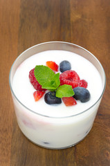 yogurt with different berries and mint in a glass beaker