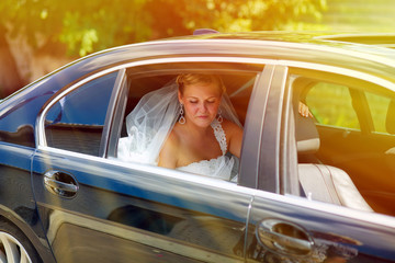 Naklejka premium sunlight blonde bride at a wedding sitting in a car