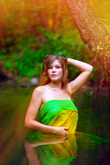 sunlight blonde young woman standing waist-deep water in river i