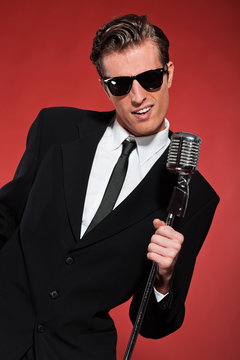 Retro fifties singer with vintage microphone and sunglasses. Stu